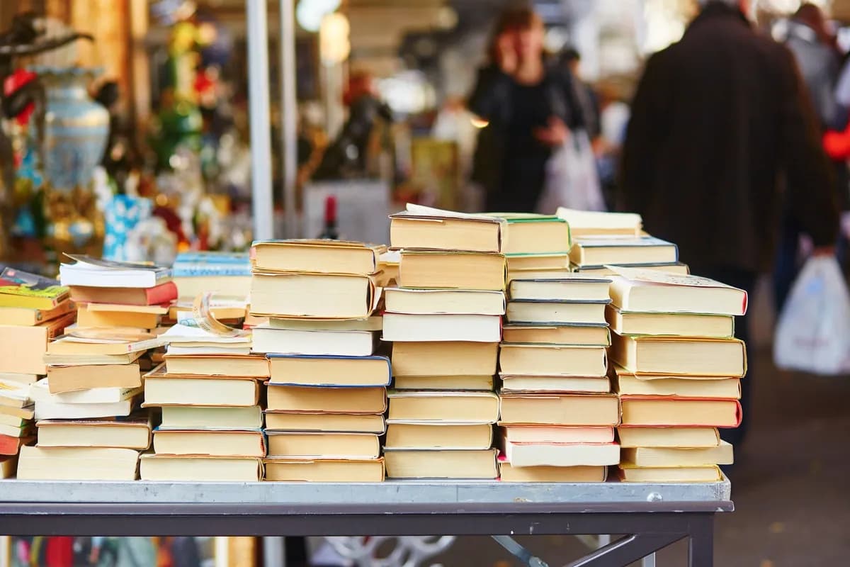 Stacks of books on a table at a book market.